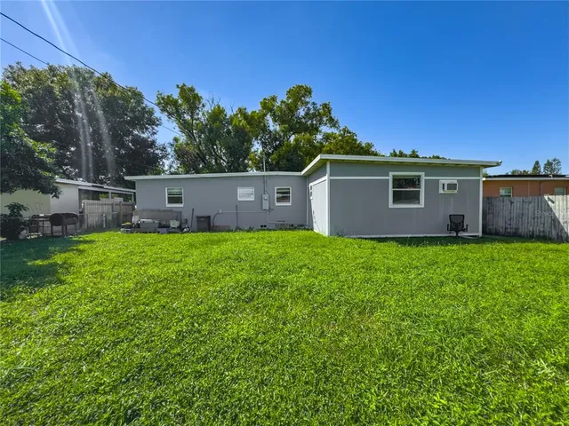 a view of a house with backyard and a tree