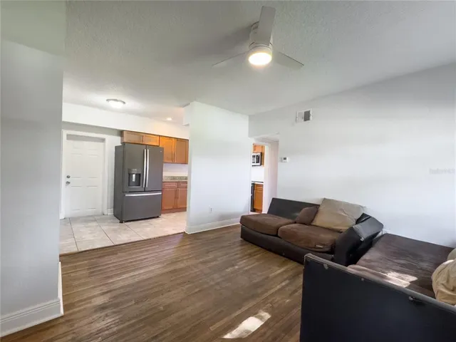a living room with furniture and a wooden floor