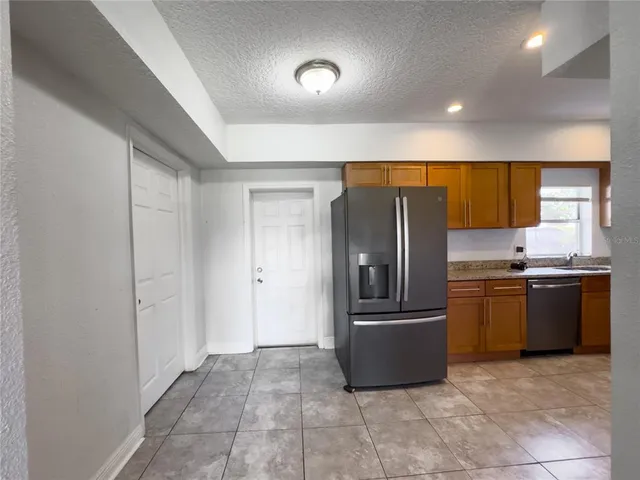 a kitchen with stainless steel appliances granite countertop a refrigerator and a sink