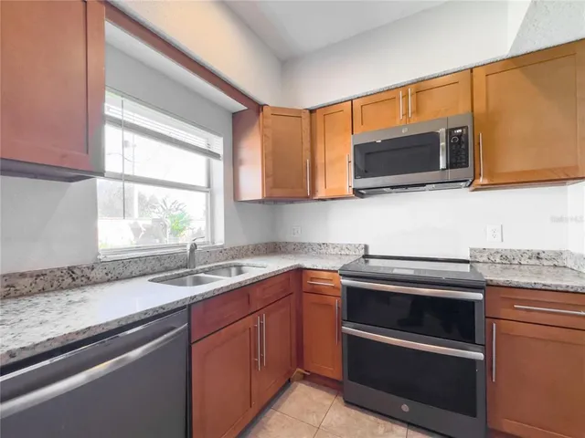 a kitchen with granite countertop a sink and steel appliances