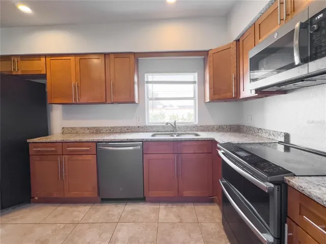 a kitchen with stainless steel appliances granite countertop a sink and dishwasher a stove top oven with wooden floor