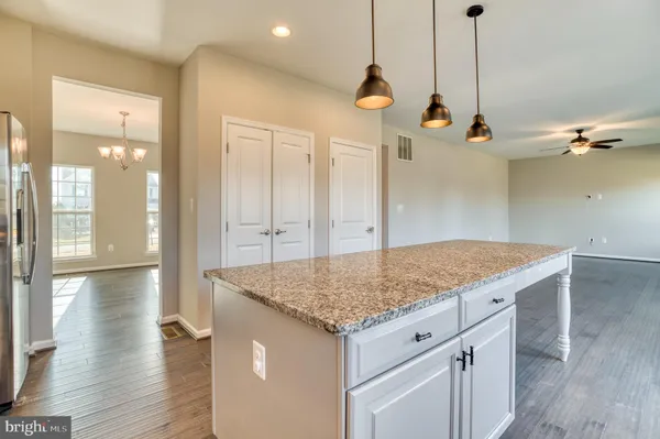 a view of a kitchen island wooden floor and a view of living room
