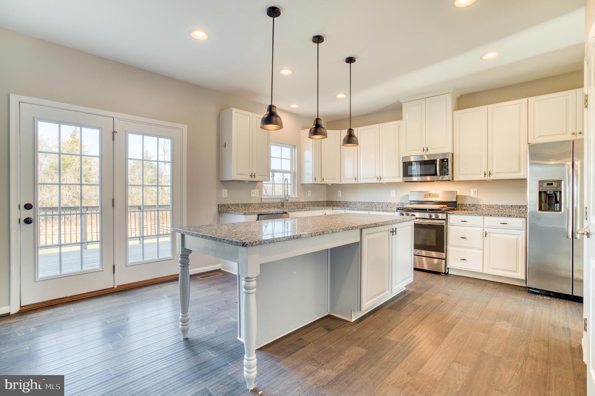 14510 Kingsmill Way Culpeper, VA 22701 - Photo 14 of 64 a large kitchen with white cabinets and wooden floor