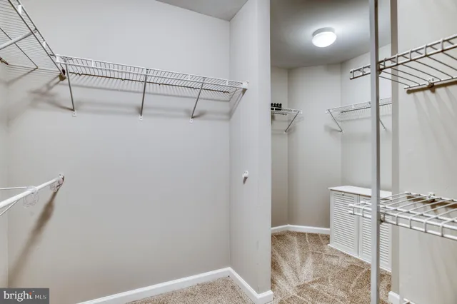 an empty room with chandelier fan and closet area