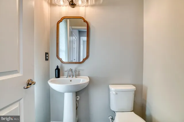 a bathroom with a toilet sink and mirror
