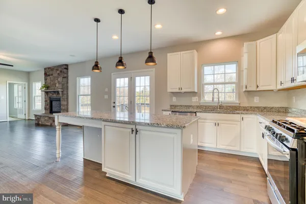 a kitchen with stainless steel appliances granite countertop wooden floors sink and cabinets