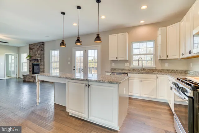 a kitchen with stainless steel appliances granite countertop wooden floors sink and cabinets