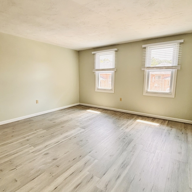 364 Neponset Street, Unit K Canton, MA 02021 - Photo 11 of 15 an empty room with wooden floor and windows