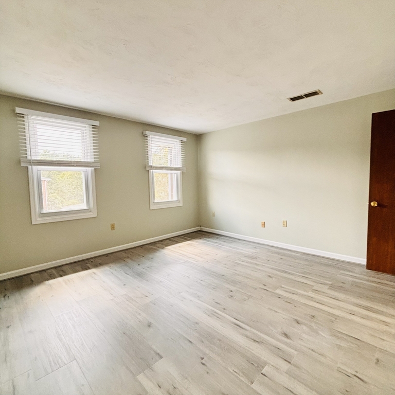 364 Neponset Street, Unit K Canton, MA 02021 - Photo 13 of 15 an empty room with wooden floor and windows