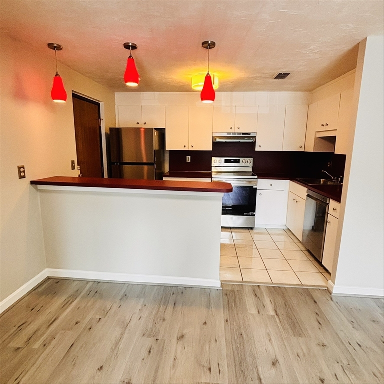 364 Neponset Street, Unit K Canton, MA 02021 - Photo 3 of 15 a kitchen with stainless steel appliances a stove and wooden floor