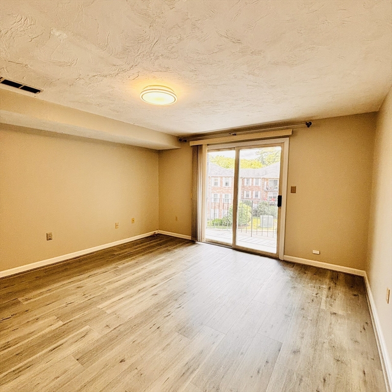 364 Neponset Street, Unit K Canton, MA 02021 - Photo 5 of 15 a view of an empty room with wooden floor and a window