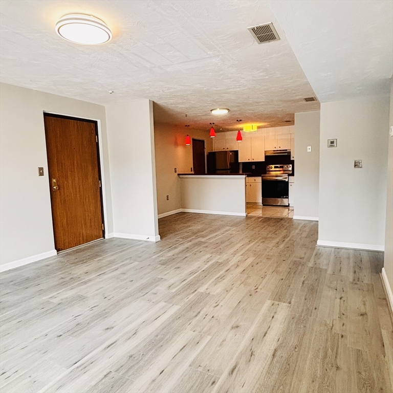 364 Neponset Street, Unit K Canton, MA 02021 - Photo 7 of 15 a view of a living room hardwood floor and a kitchen