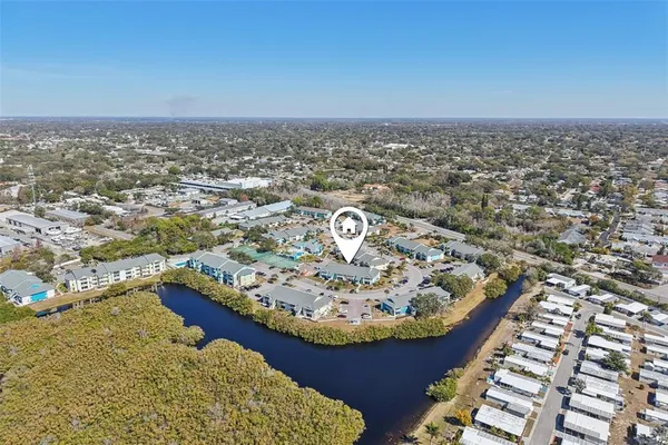 an aerial view of residential houses with outdoor space and lake view