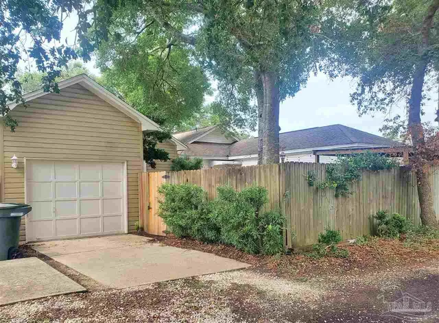 a backyard of a house with plants and tree