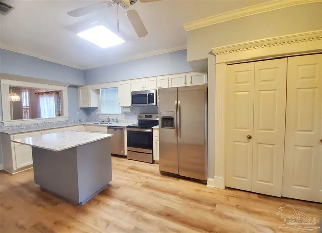 a kitchen with stainless steel appliances granite countertop a refrigerator a sink a stove a microwave and island