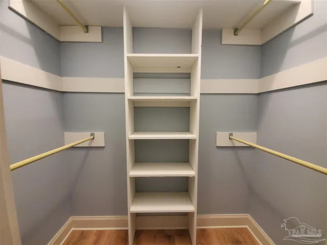 a view of walk in closet with clothes and shoes