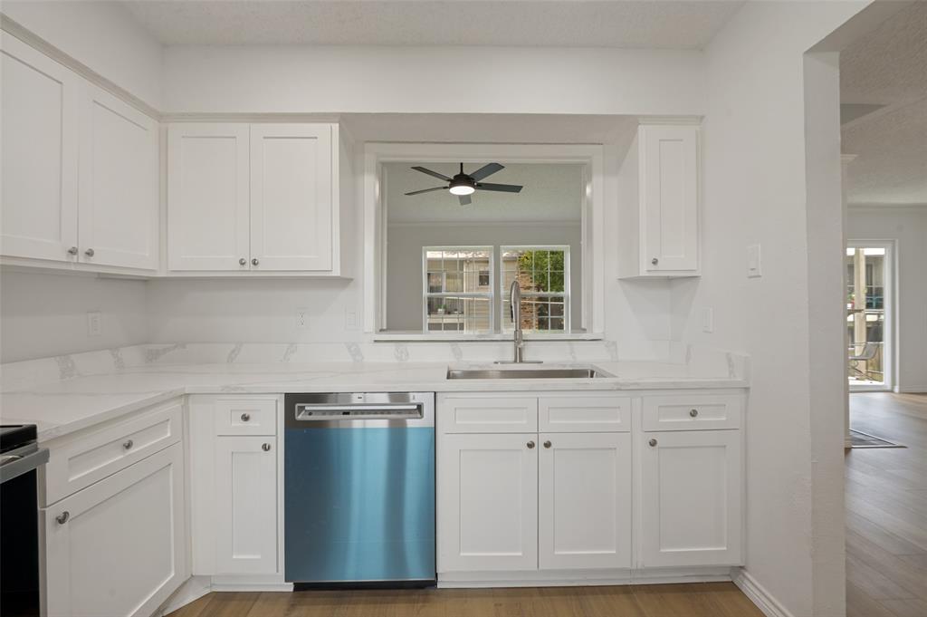 5300 Keller Springs Road, Unit 2042 Dallas, TX 75248 - Photo 6 of 28 Kitchen featuring white shaker-style cabinetry, light-toned countertops with a subtle veining pattern, and a stainless steel sink with a gooseneck faucet