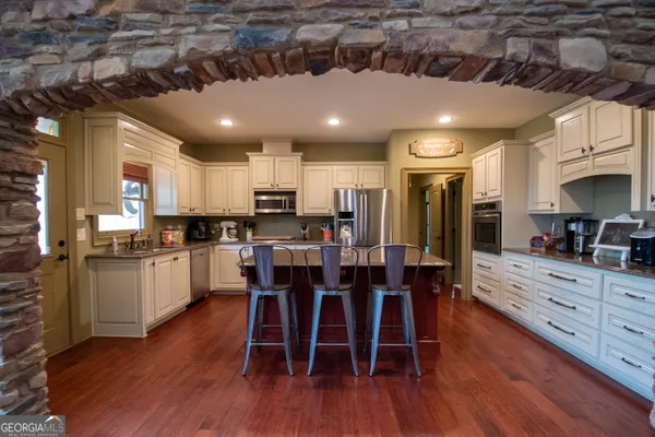 a kitchen with granite countertop a stove and a wooden floors