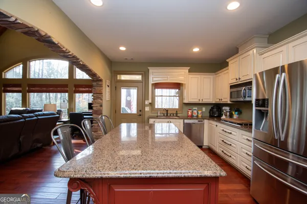 a kitchen with stainless steel appliances kitchen island hardwood floor sink and stove