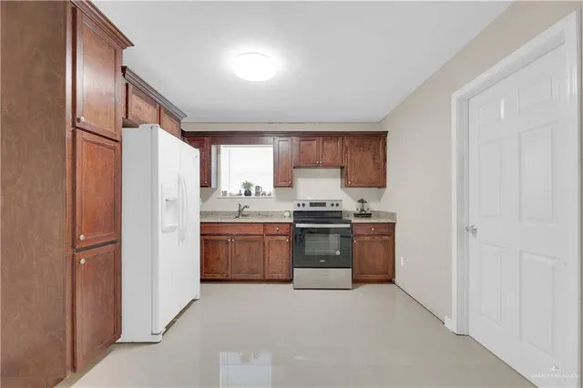 a kitchen with stainless steel appliances granite countertop a refrigerator sink and stove