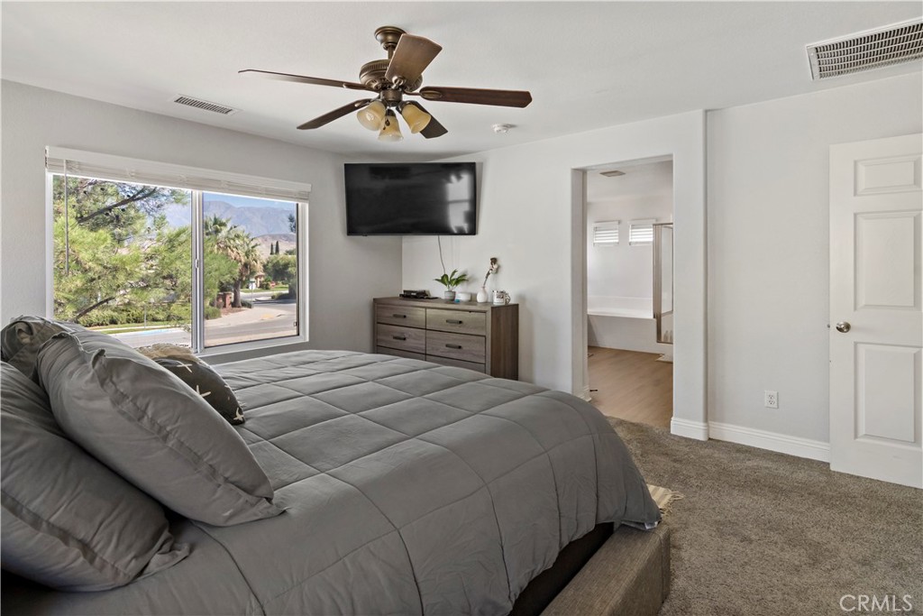 1664 Rigel Street Beaumont, CA 92223 - Photo 17 of 32 a bedroom with a bed and a chandelier