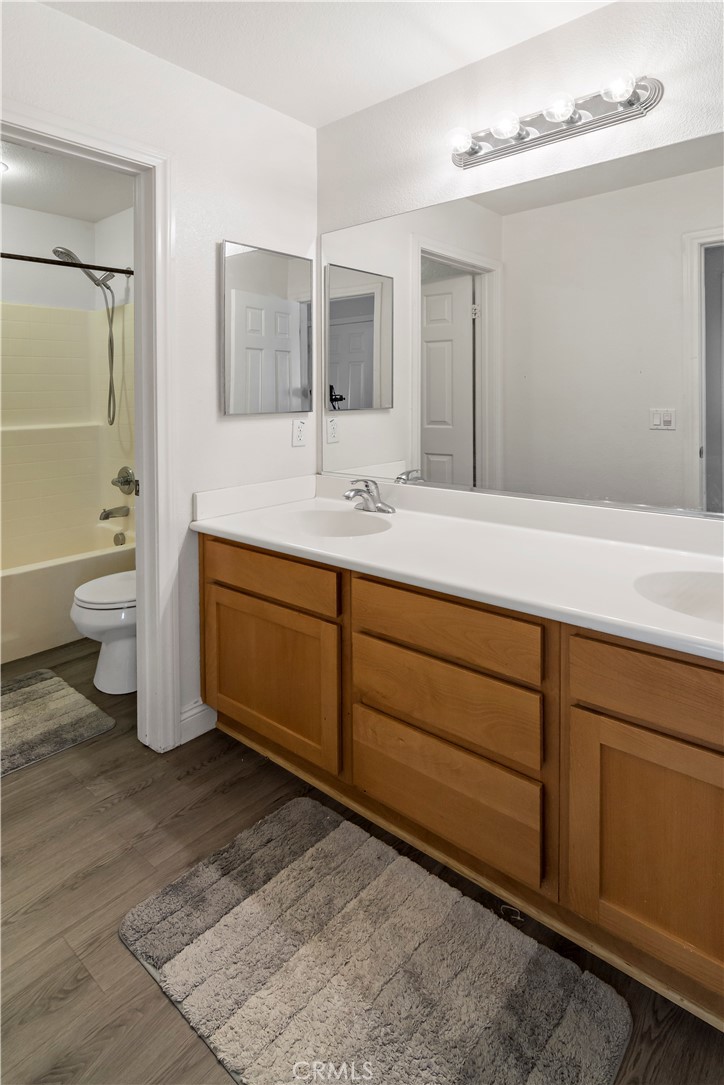 1664 Rigel Street Beaumont, CA 92223 - Photo 22 of 32 a spacious bathroom with a double vanity sink toilet and a mirror