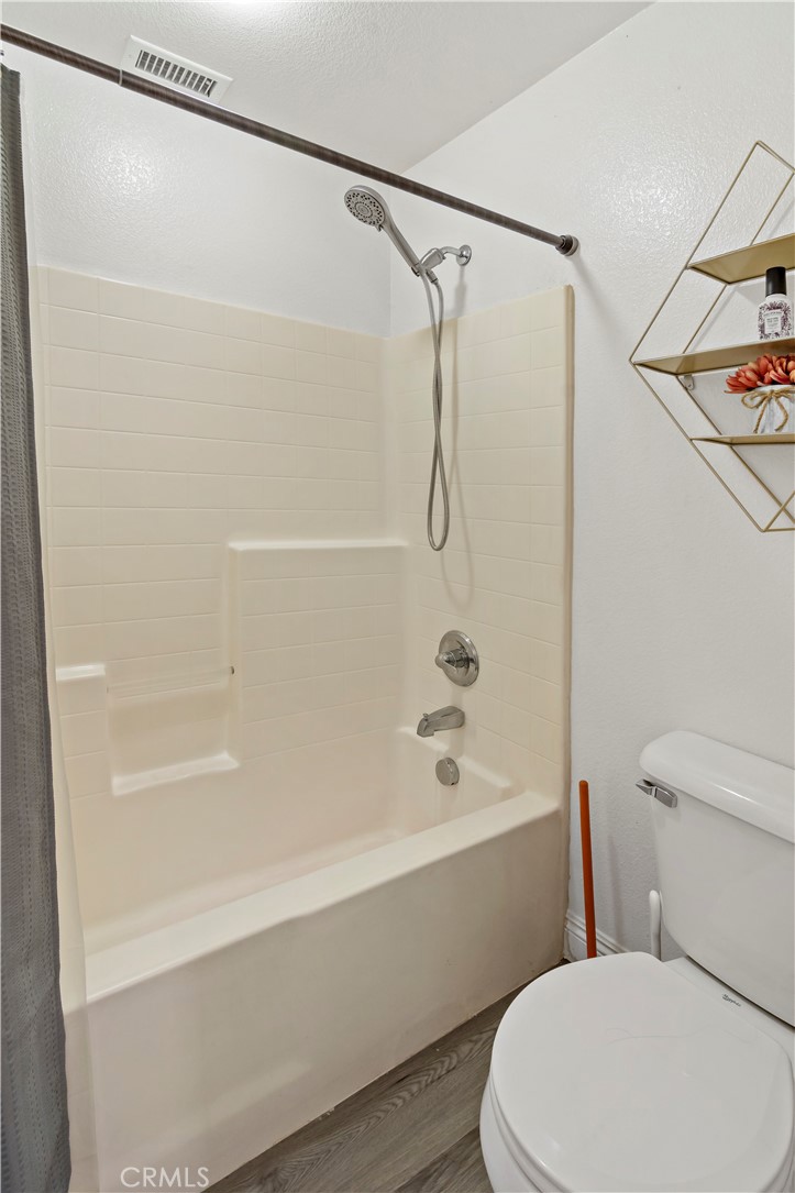 1664 Rigel Street Beaumont, CA 92223 - Photo 23 of 32 a white toilet sitting next to a bath tub and a shower