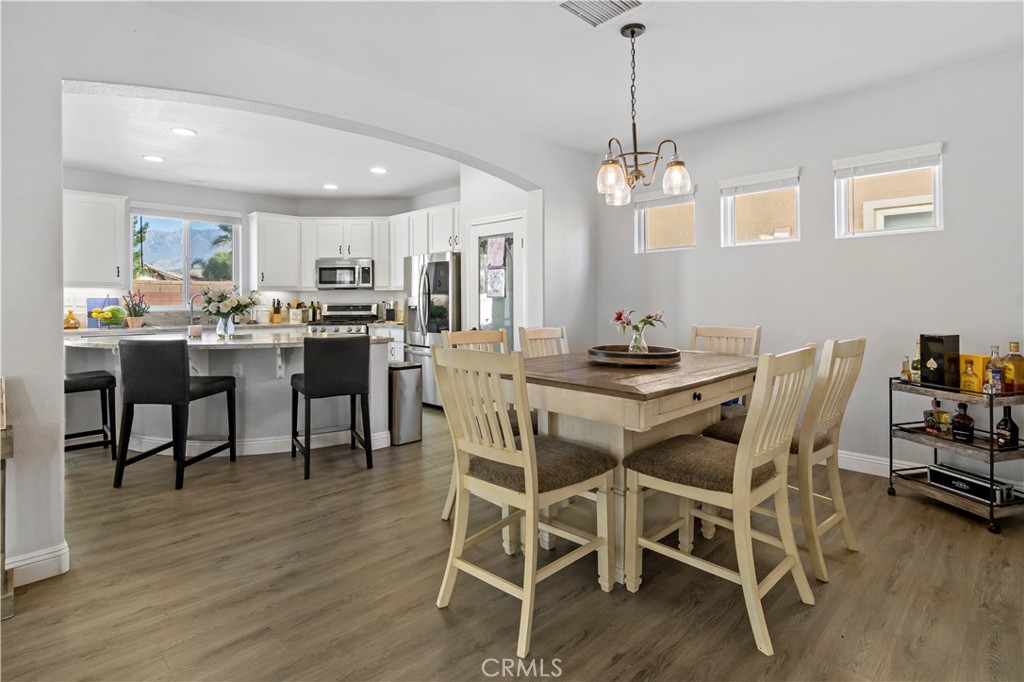 1664 Rigel Street Beaumont, CA 92223 - Photo 8 of 32 a dining room with furniture wooden floor and a chandelier