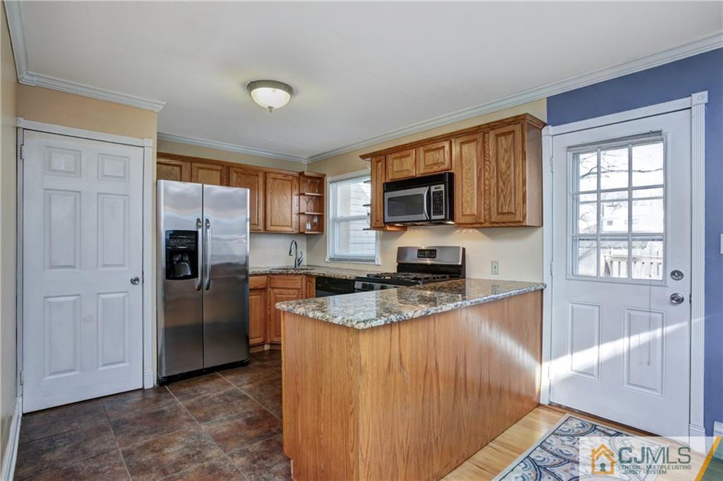 5 Baldwin Road Edison, NJ 08817 - Photo 7 of 25 a kitchen with granite countertop a refrigerator stove and microwave