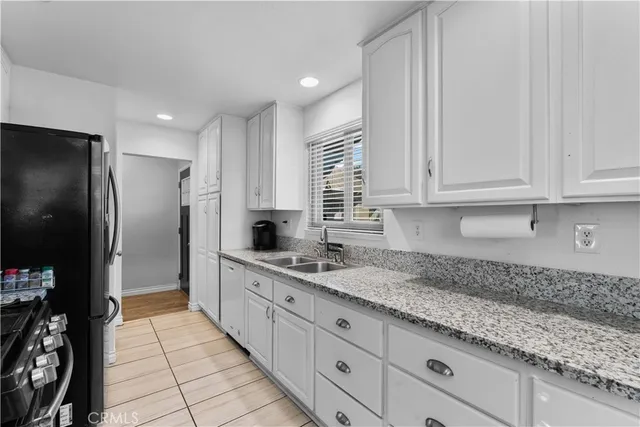 a kitchen with granite countertop a sink stainless steel appliances and cabinets