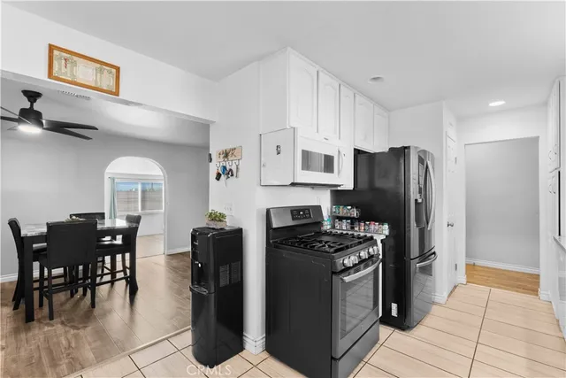 a kitchen with stainless steel appliances a refrigerator stove microwave and white cabinets