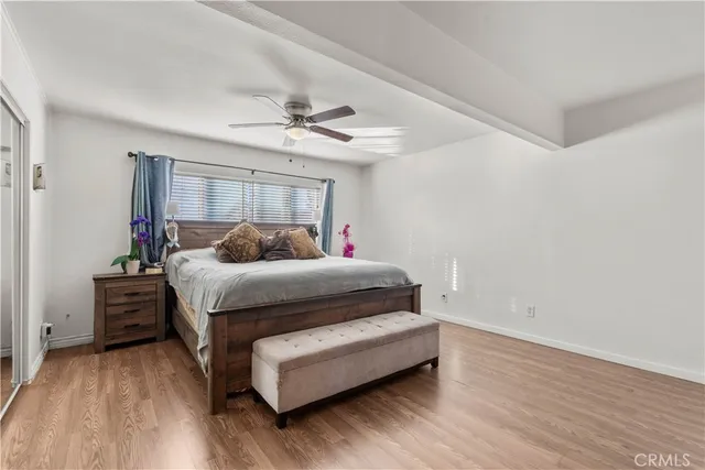 a bedroom with a bed and wooden floor