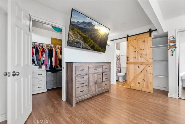 a view of a bedroom with wooden floor and cabinet