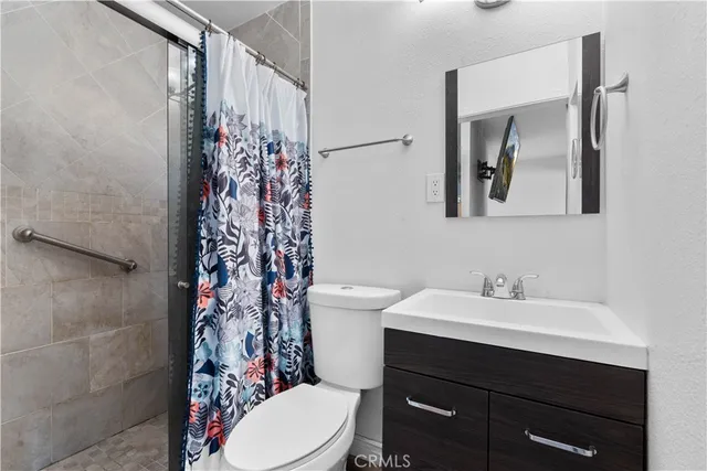 a bathroom with a sink a toilet and shower curtain