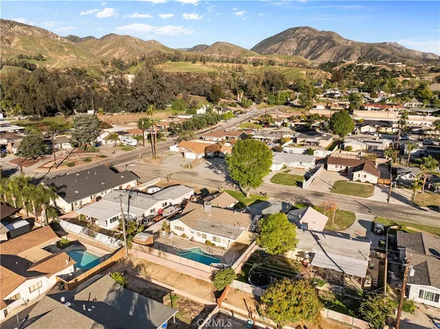 an aerial view of residential houses with outdoor space and trees