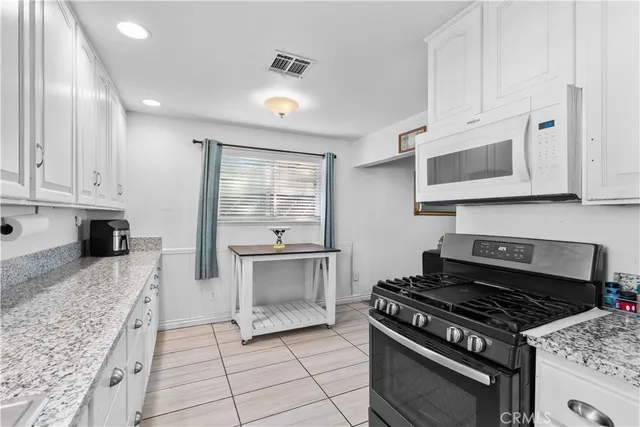 a kitchen with granite countertop a stove and a sink