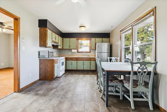 a kitchen with a table chairs sink and cabinets