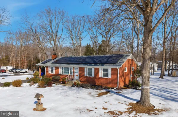 a front view of a house with a tree