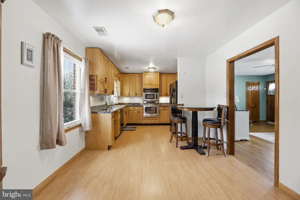 a kitchen with a table chairs refrigerator and cabinets