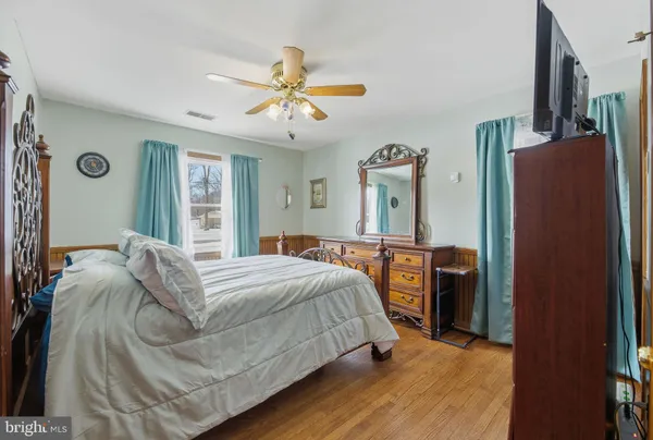a bedroom with a bed dresser and a window