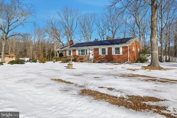 a front view of a house with a yard covered with snow