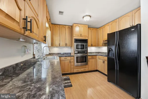 a kitchen with granite countertop a refrigerator and a sink