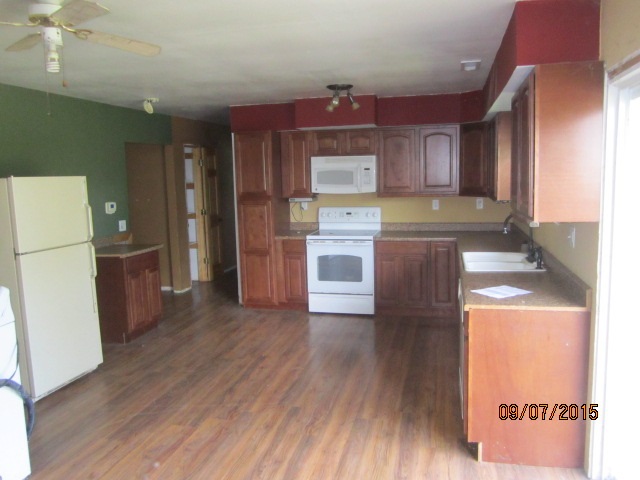 4404 East Walden Road Byron, IL 61010 - Photo 6 of 7 a kitchen with stainless steel appliances a refrigerator and wooden floor