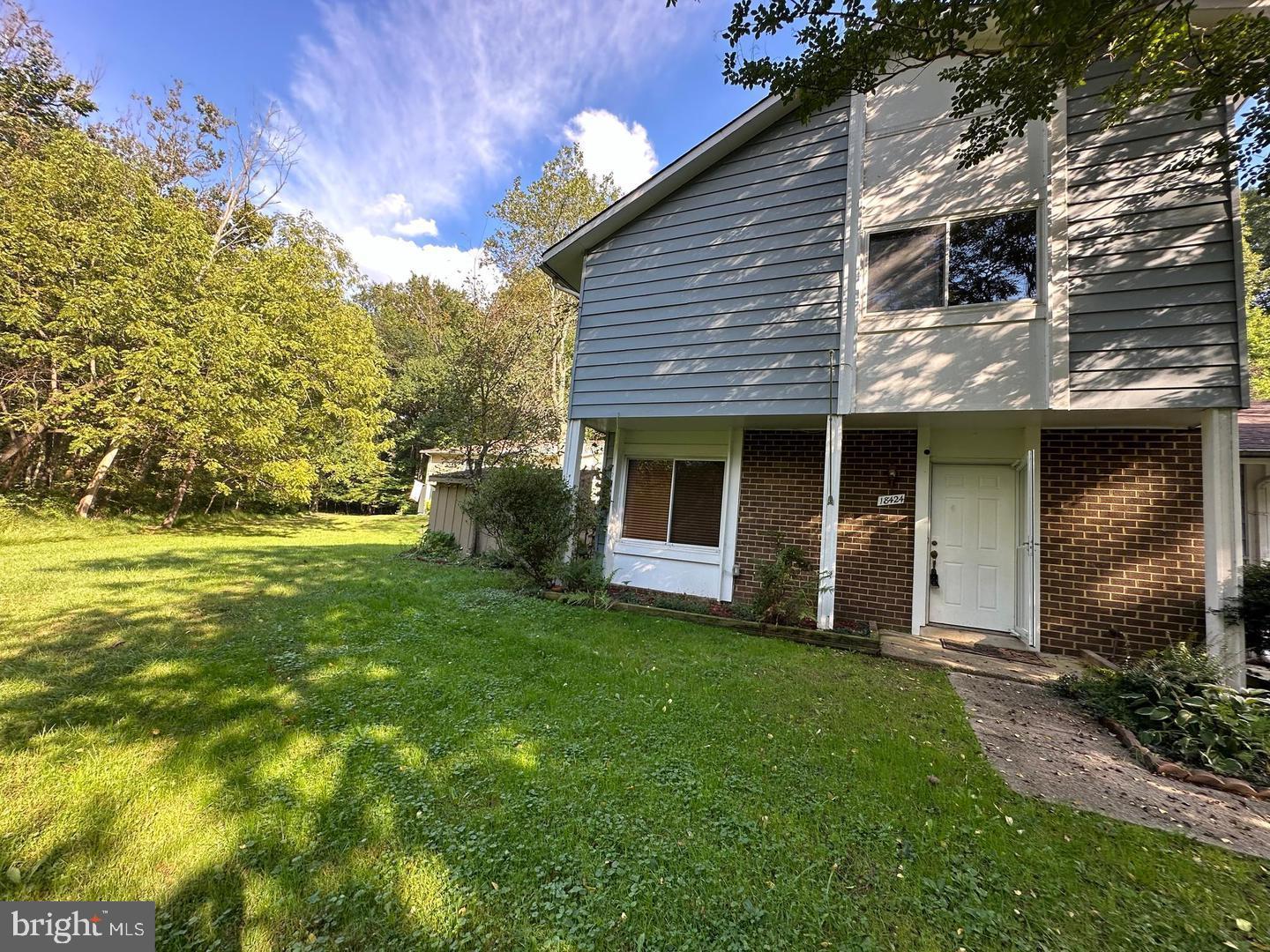 a view of a house with a yard and tree s