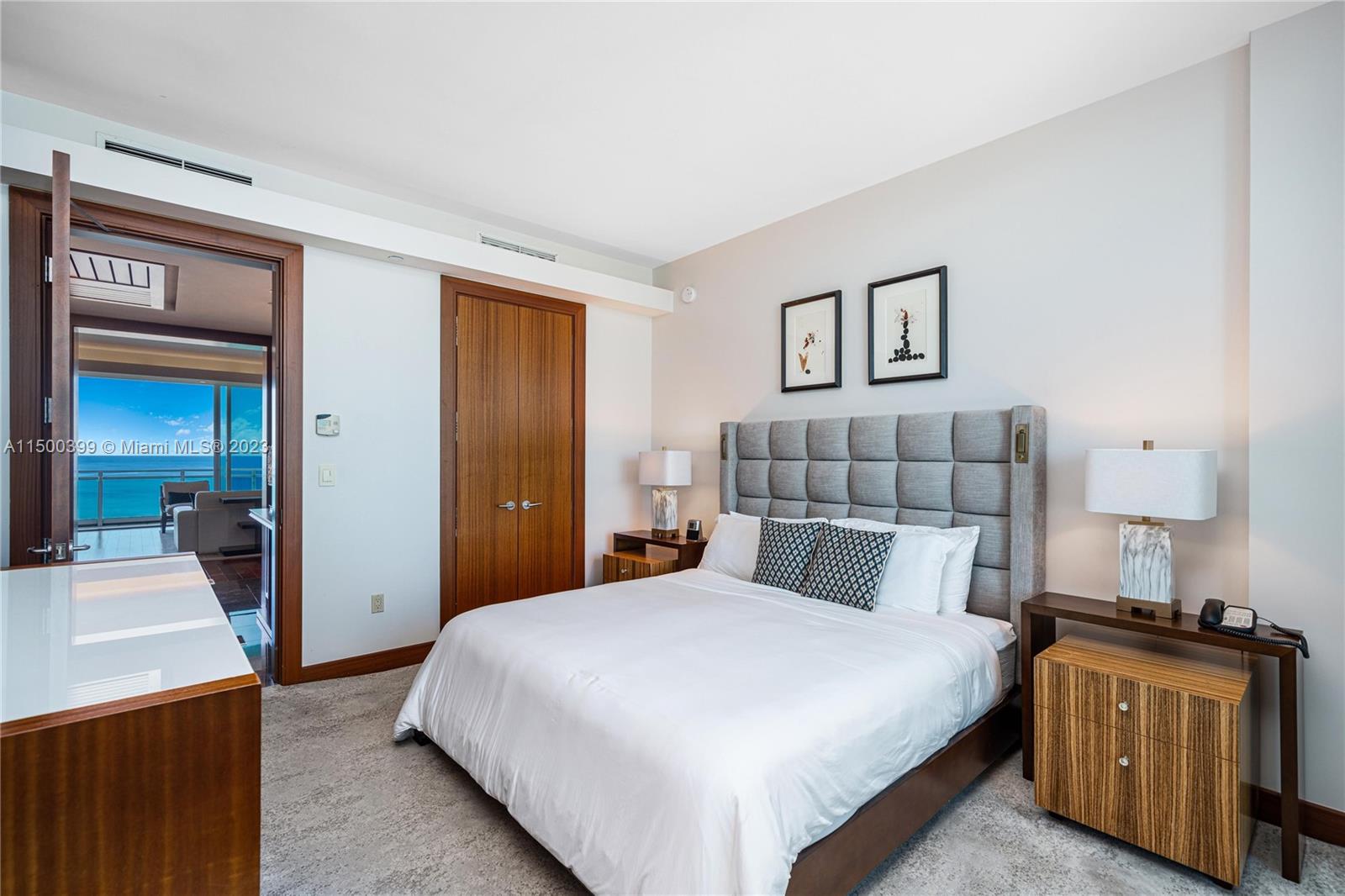 10295 Collins Avenue, Unit 1217 Bal Harbour, FL 33154 - Photo 22 of 26 a bedroom with a large bed and a lamp on table