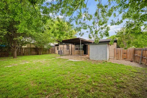 a backyard of a house with table and chairs