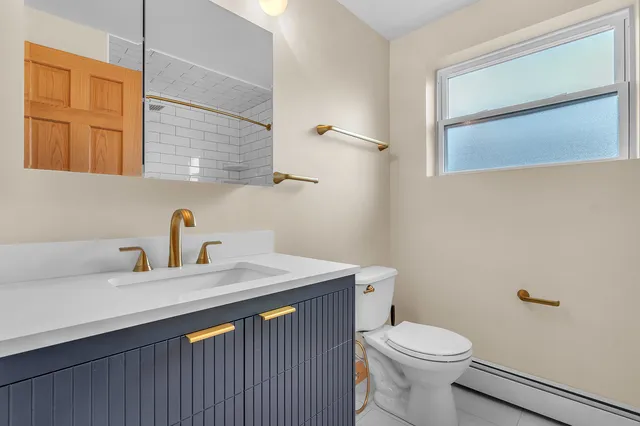 a bathroom with a sink a toilet and mirror