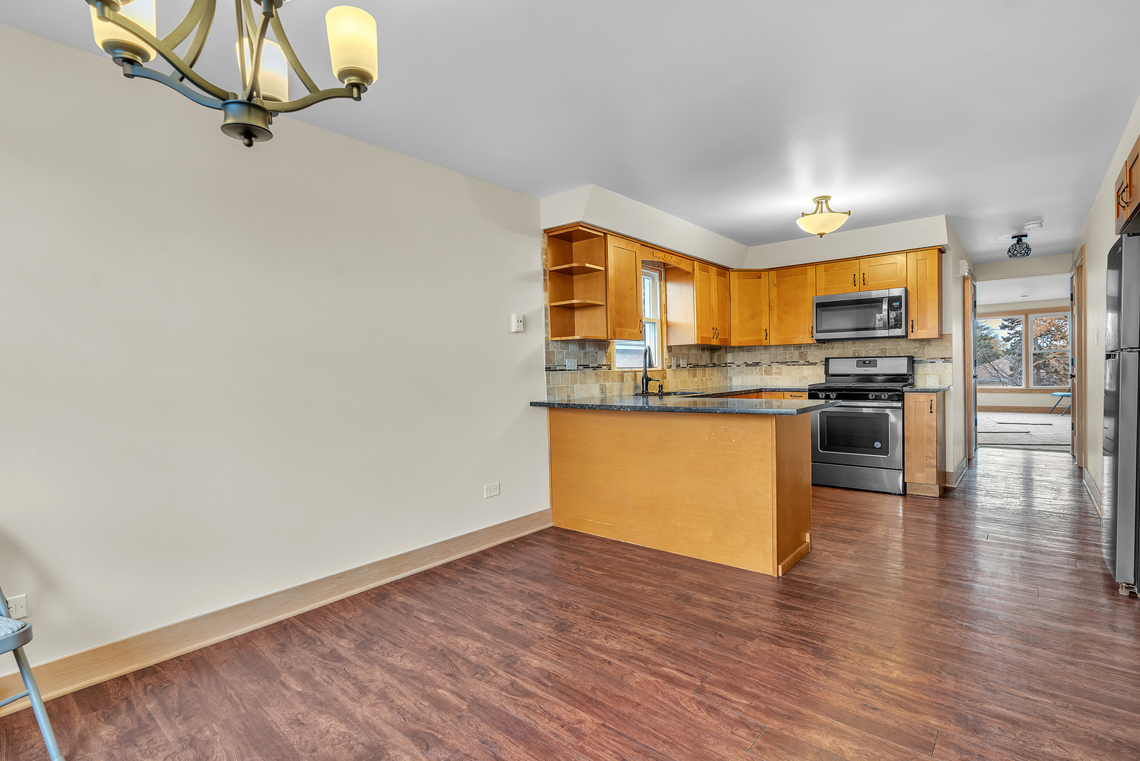 6048 West 79th Street Burbank, IL 60459 - Photo 21 of 34 an open kitchen with wooden floor and stainless steel appliances