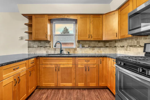 a kitchen with stainless steel appliances granite countertop a sink stove and cabinets
