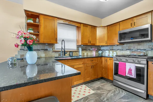 a kitchen with granite countertop a sink stove and cabinets